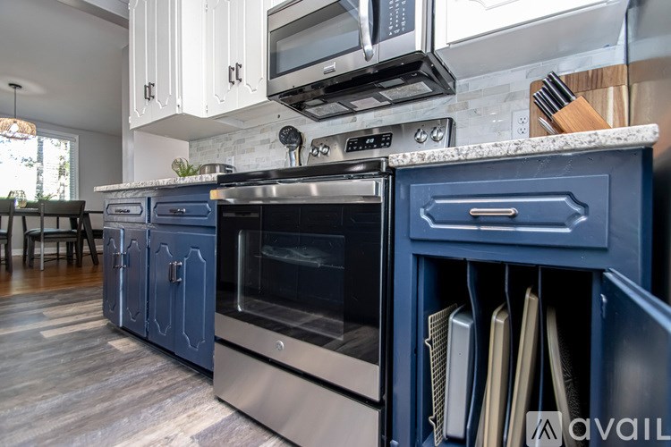 A kitchen with a blue drawer and stainless steel appliances.