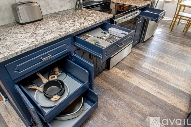 A kitchen with a granite countertop and blue drawers.