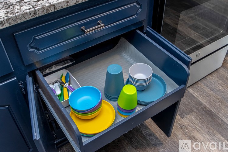 A drawer full of colorful plates and bowls.