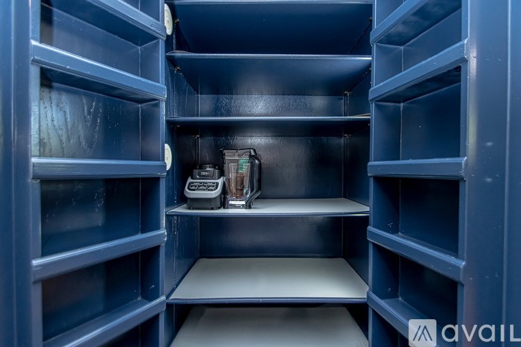 A kitchen pantry with a blender on the counter.