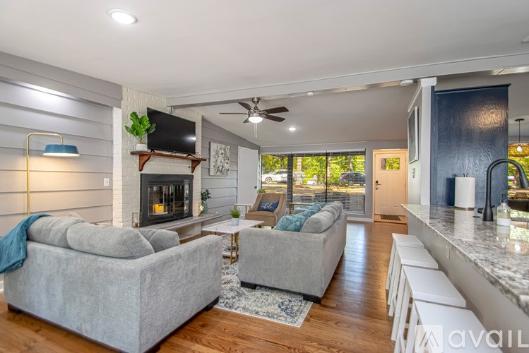 A living room with a grey couch and a fireplace.