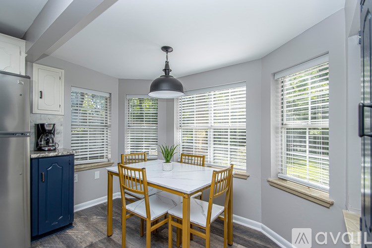A kitchen with a table and chairs.