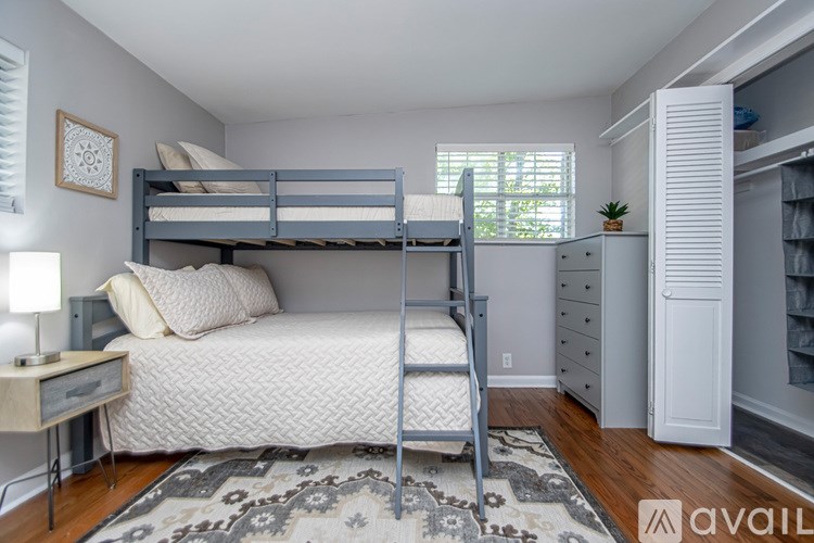 A bedroom with a bunk bed and a dresser.