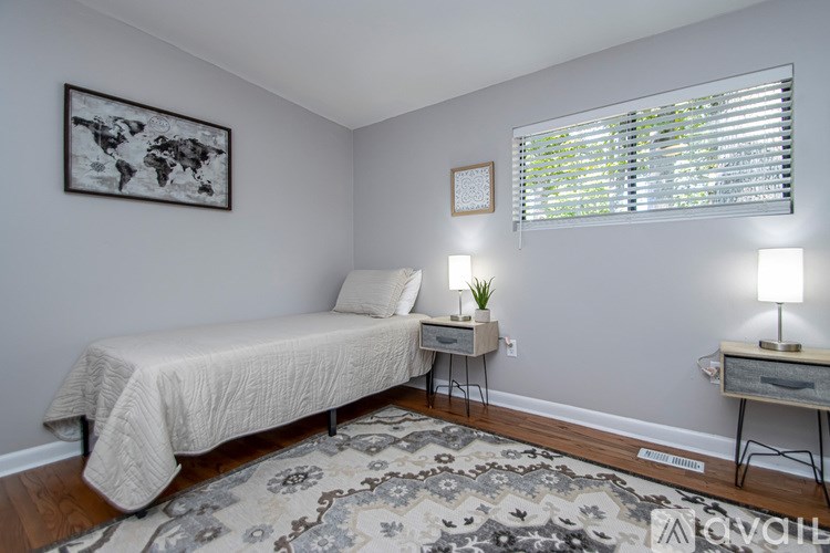 A bedroom with a bed, desk, and chair.