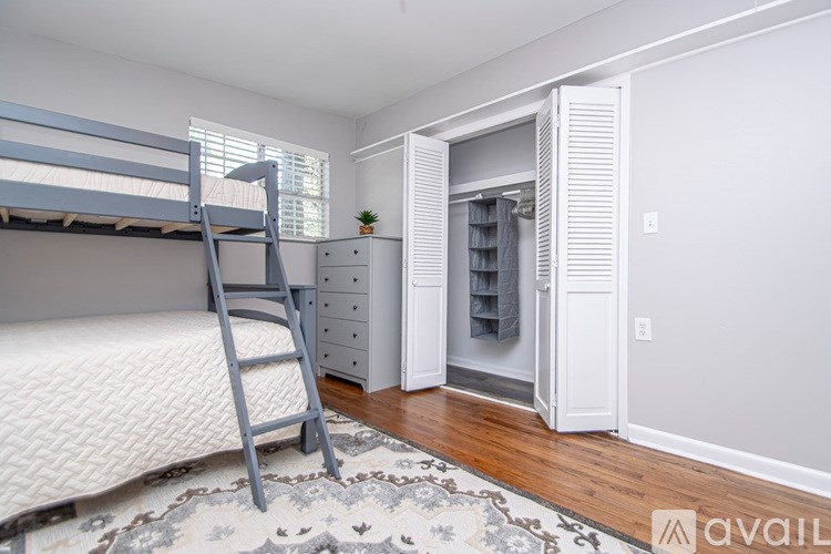 A bedroom with a bunk bed and a dresser.