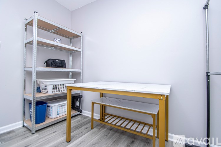 A room with a desk, chair, and shelving unit.