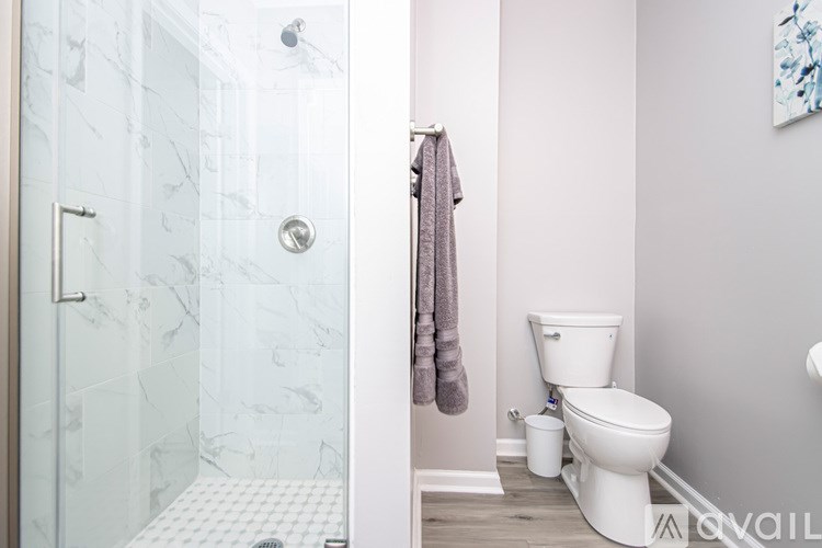 A white toilet sits next to a glass shower stall.