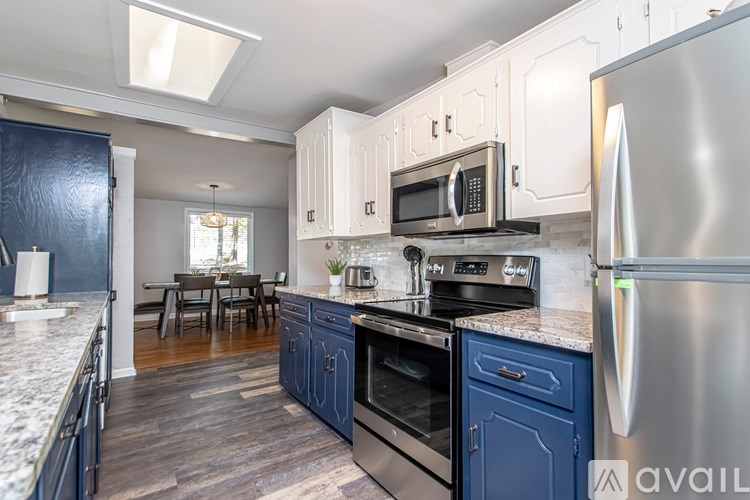 A kitchen with a refrigerator, oven, and microwave.