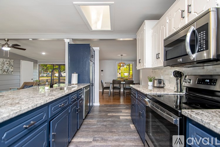 A kitchen with blue cabinets and a black stove top oven.