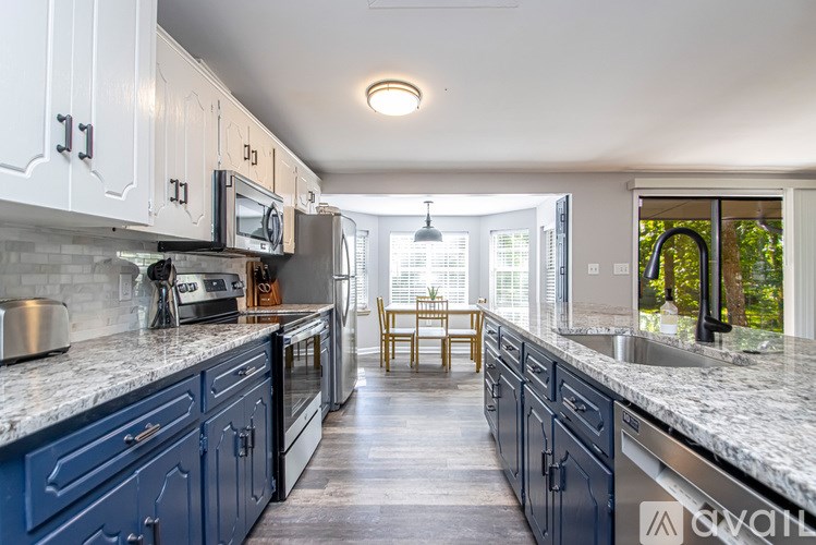 A kitchen with blue cabinets and a marble countertop.