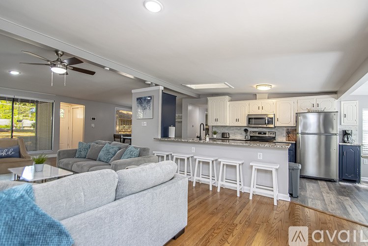 A modern kitchen with a bar and a grey couch.