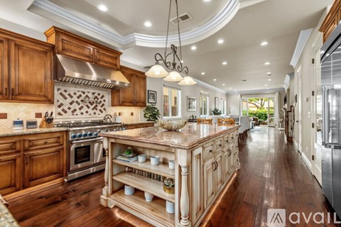 A kitchen with wooden cabinets and a large island in the middle.