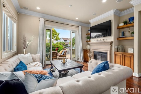 A living room with a white couch and a fireplace.