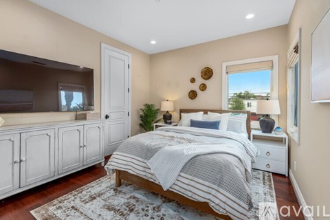 A bedroom with a large bed and a television.