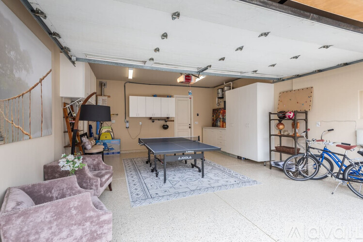 A room with a pool table, chairs, and bicycles.