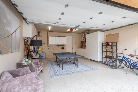 A room with a pool table, chairs, and bicycles.