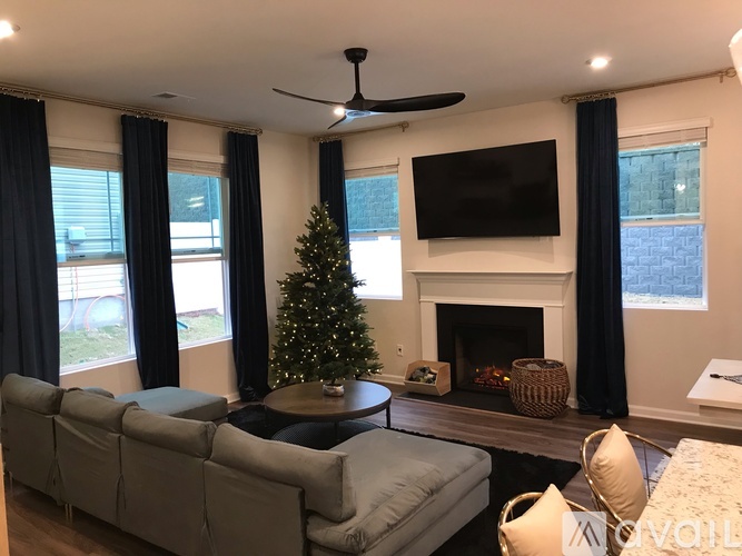 A living room with a Christmas tree and a fireplace.