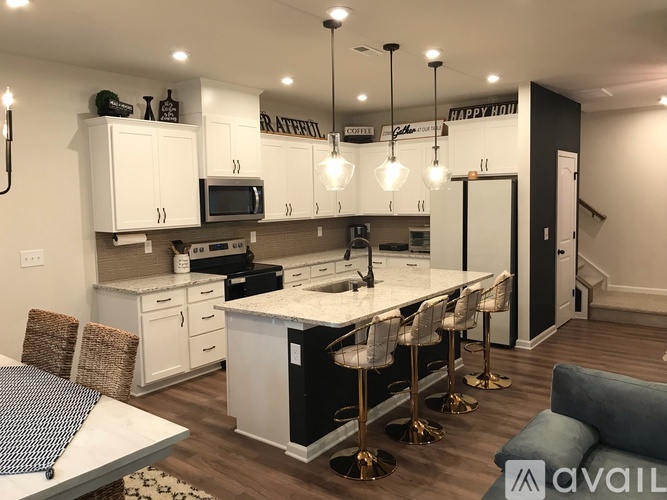 A kitchen with white cabinets and a marble countertop.