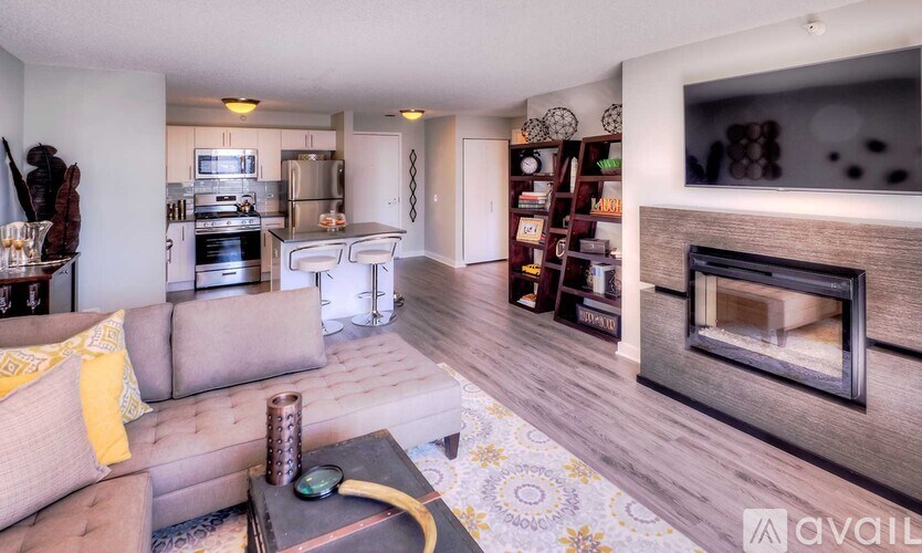 A living room with a grey couch and a fireplace.