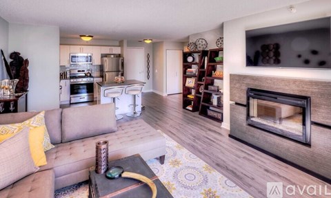 A living room with a grey couch and a fireplace.