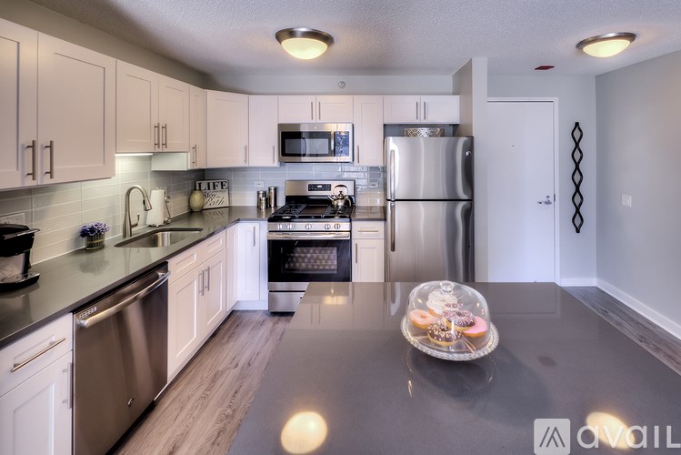 A kitchen with a granite countertop and stainless steel appliances.