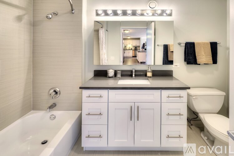 A modern bathroom with a white tub and sink.