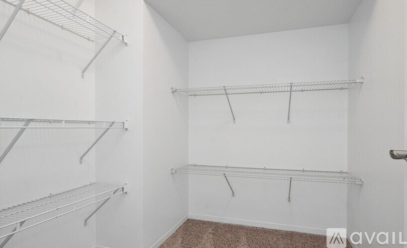 Empty room with white walls and metal shelving.