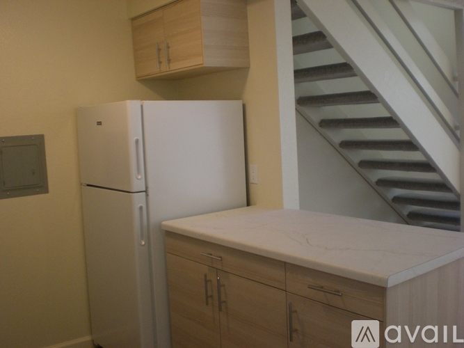A white refrigerator with a brown handle is open.