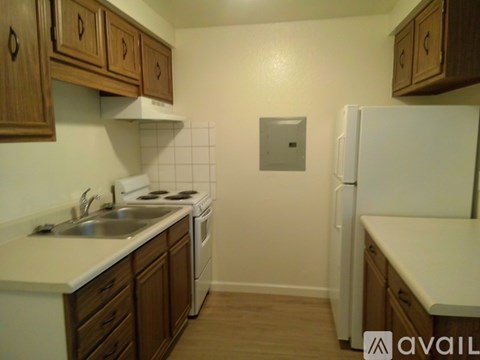 A kitchen with white appliances and wooden cabinets.