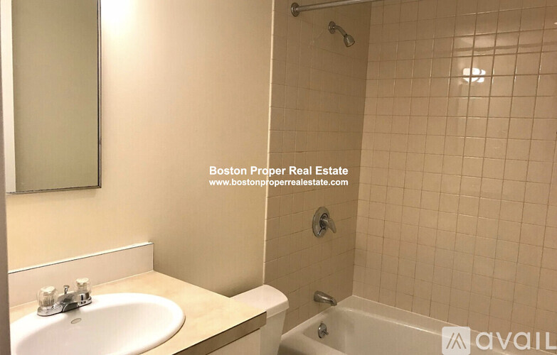 A bathroom with a sink, mirror, and bathtub.