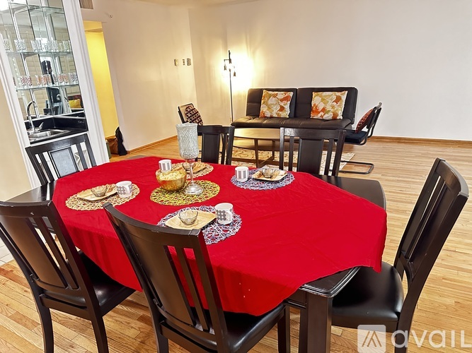 A modern dining room with a glass wall and a round table with chairs.