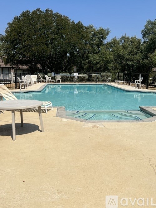 A pool with a table and chairs around it.