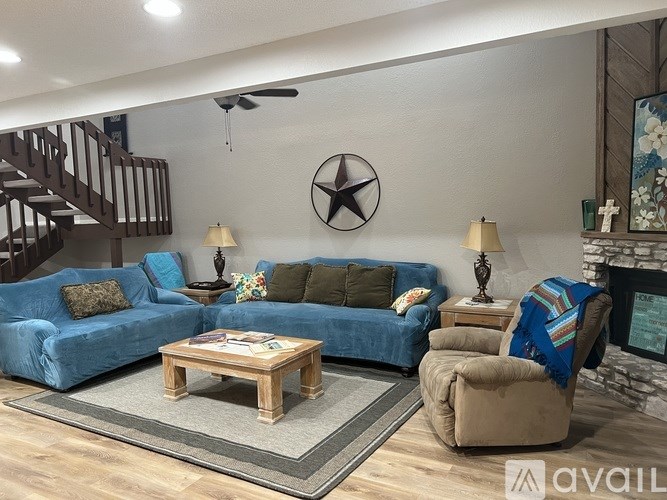 A living room with a blue couch, a wooden coffee table, and a star decoration on the wall.