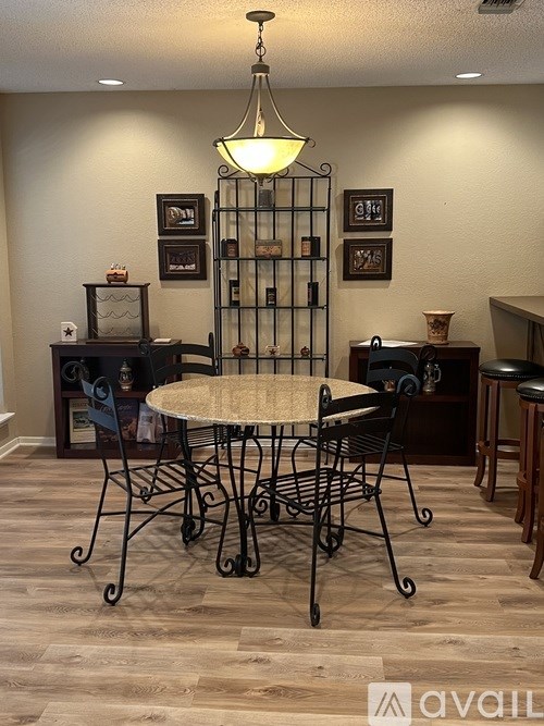 A dining room with a round table and chairs.