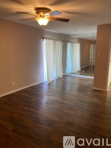 A room with wooden floors and a ceiling fan.