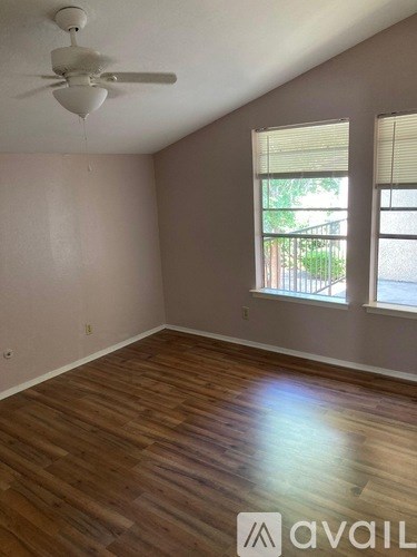 A room with a ceiling fan and wooden flooring.