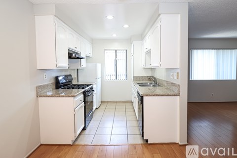 A kitchen with white cabinets and a granite countertop.