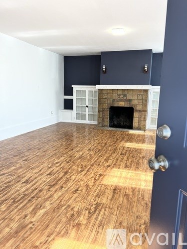 A room with a fireplace and wooden flooring.