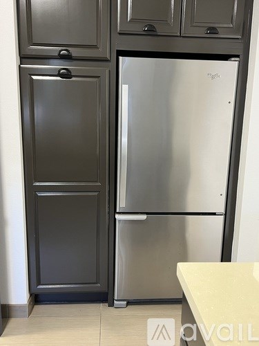 A stainless steel refrigerator with a freezer on the top and a drawer on the bottom.