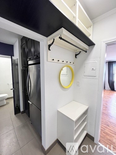 A kitchen with a stainless steel refrigerator and a white cabinet.
