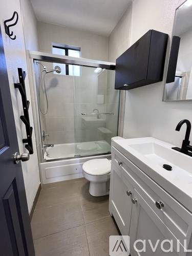 A bathroom with a toilet, sink, and shower.
