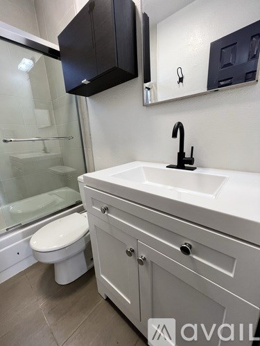 A bathroom with a white sink and a toilet.