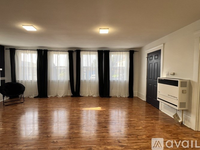 A room with wooden floors and a black chair.