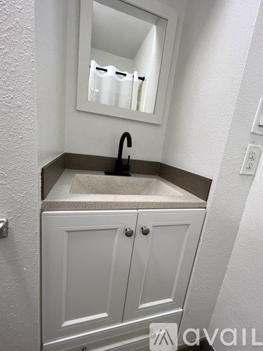 A bathroom with a sink and a mirror above it.