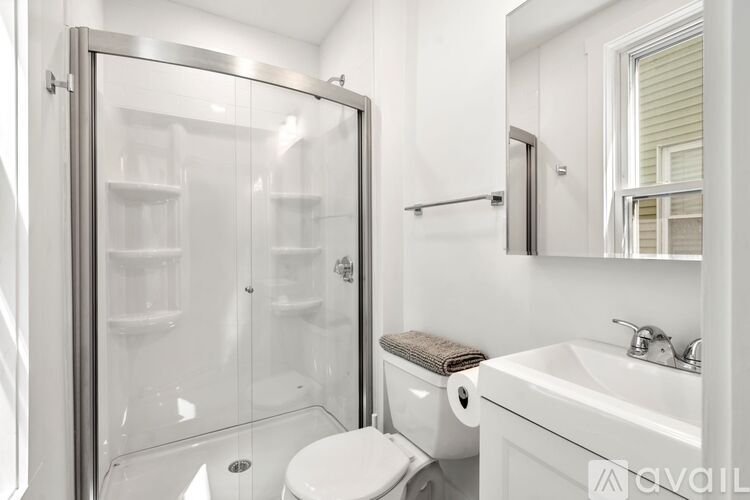 A bedroom with a white bed and a desk with a chair.