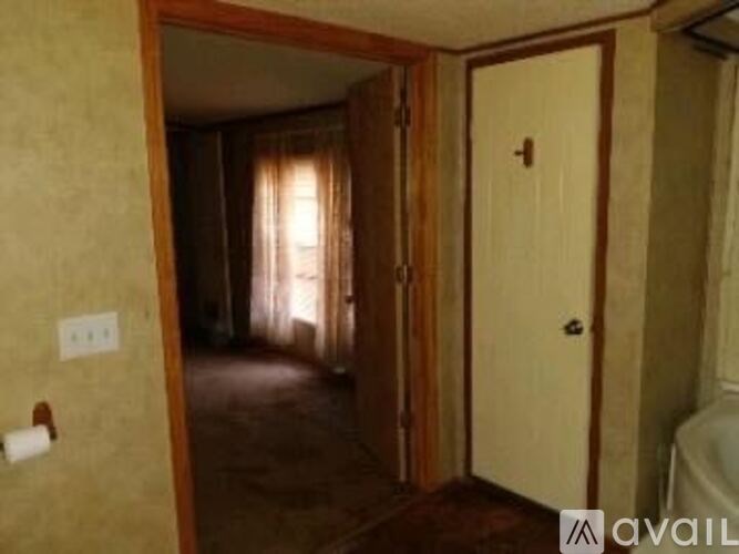 A room with a door and a window with curtains.