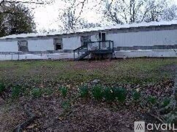 A white building with a black railing on the front.