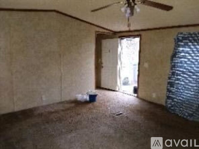 A room with a ceiling fan and a door leading outside.