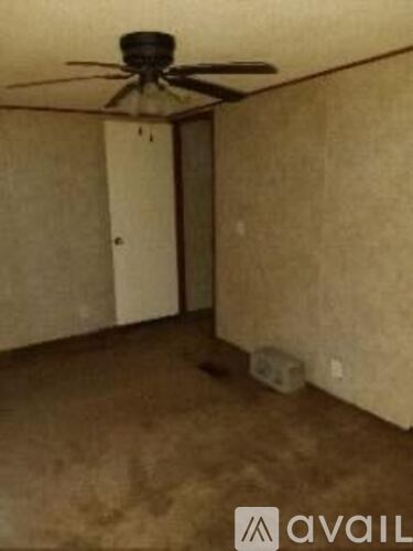 A room with a ceiling fan and a door.