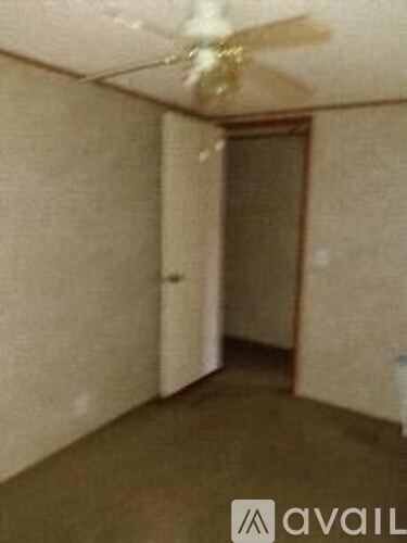 A room with a ceiling fan and a door.